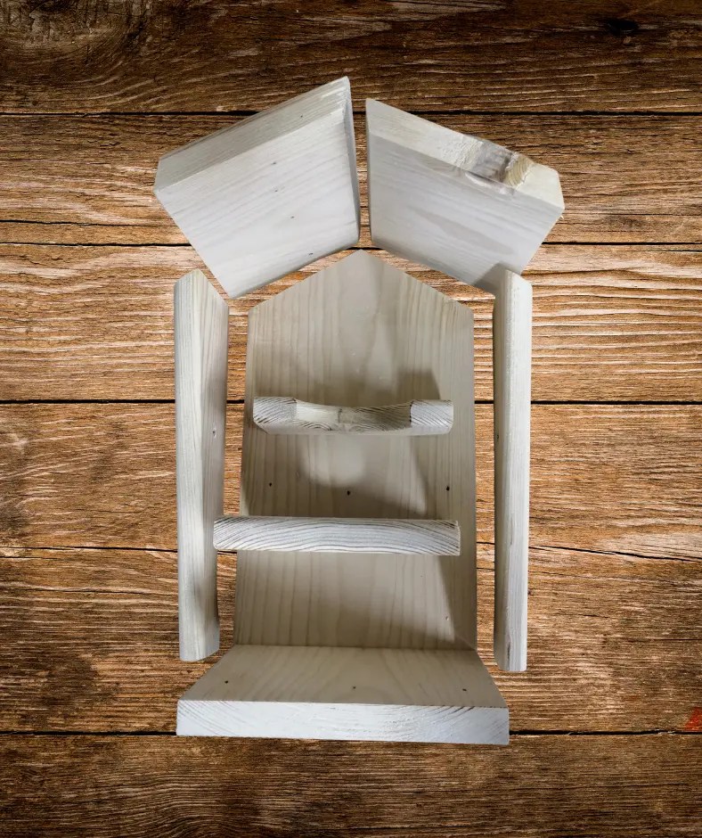 Einzelteile eines selbstgebauten Vogelfutterhauses aus hellem Holz liegen geordnet auf einer Holzoberfläche: Rückwand, Boden, Seitenwände und zwei Dachbretter.