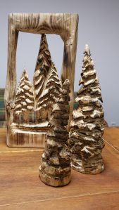 Weihnachtliche Schnitzarbeiten. 2 Weihnachtsbäume, ein Wandbild mit Tannenbäumen.