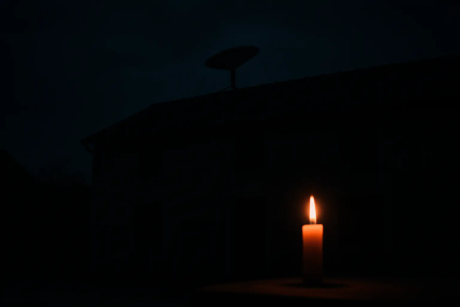 Dunkelheit mit Kerze und Starlink Antenne